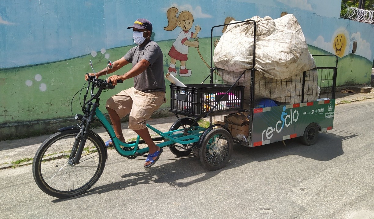 bicicleta do re-ciclo, que tem uma caçamba 